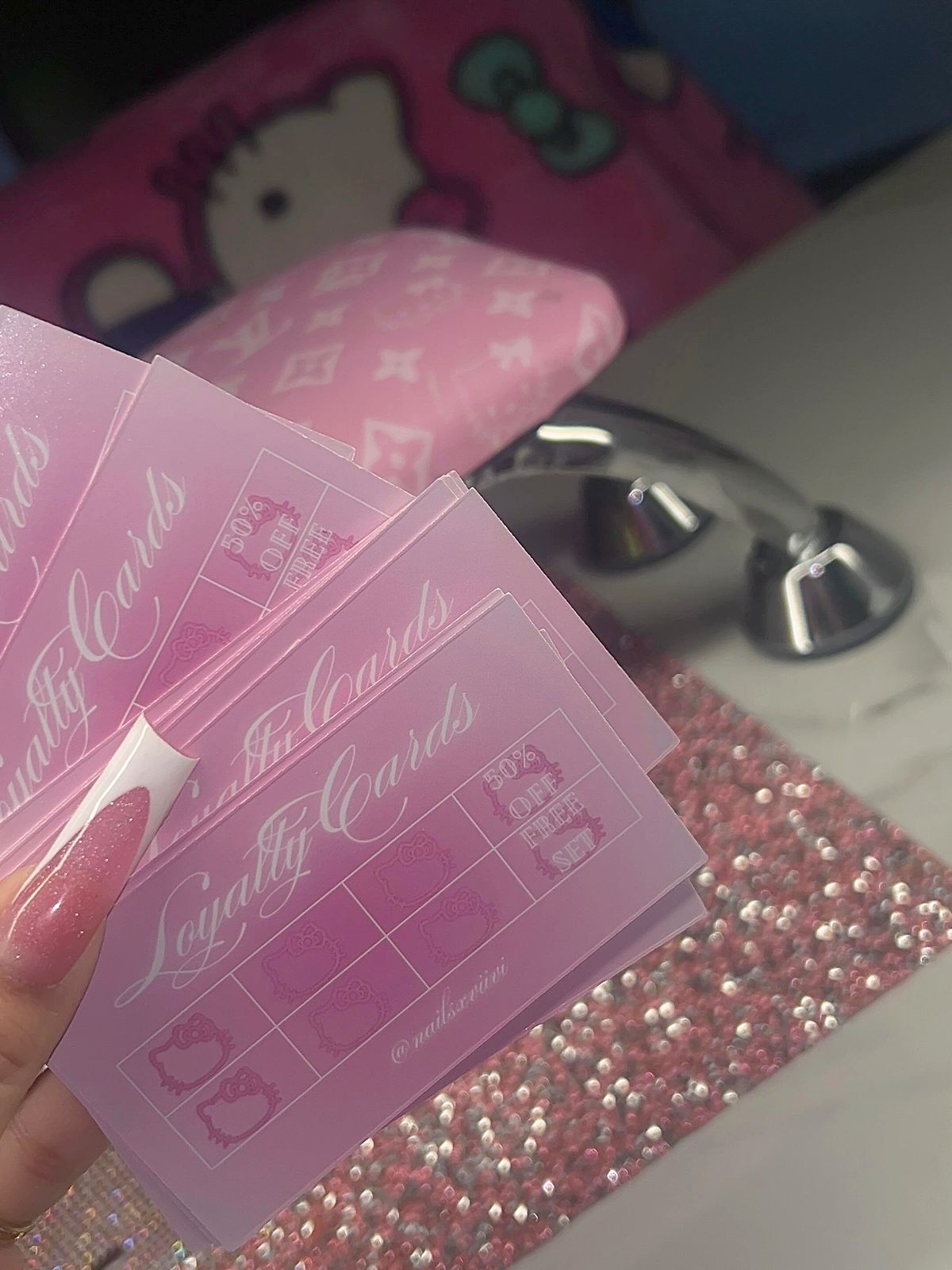 nails x viivi loyalty cards on a pink glitter desk